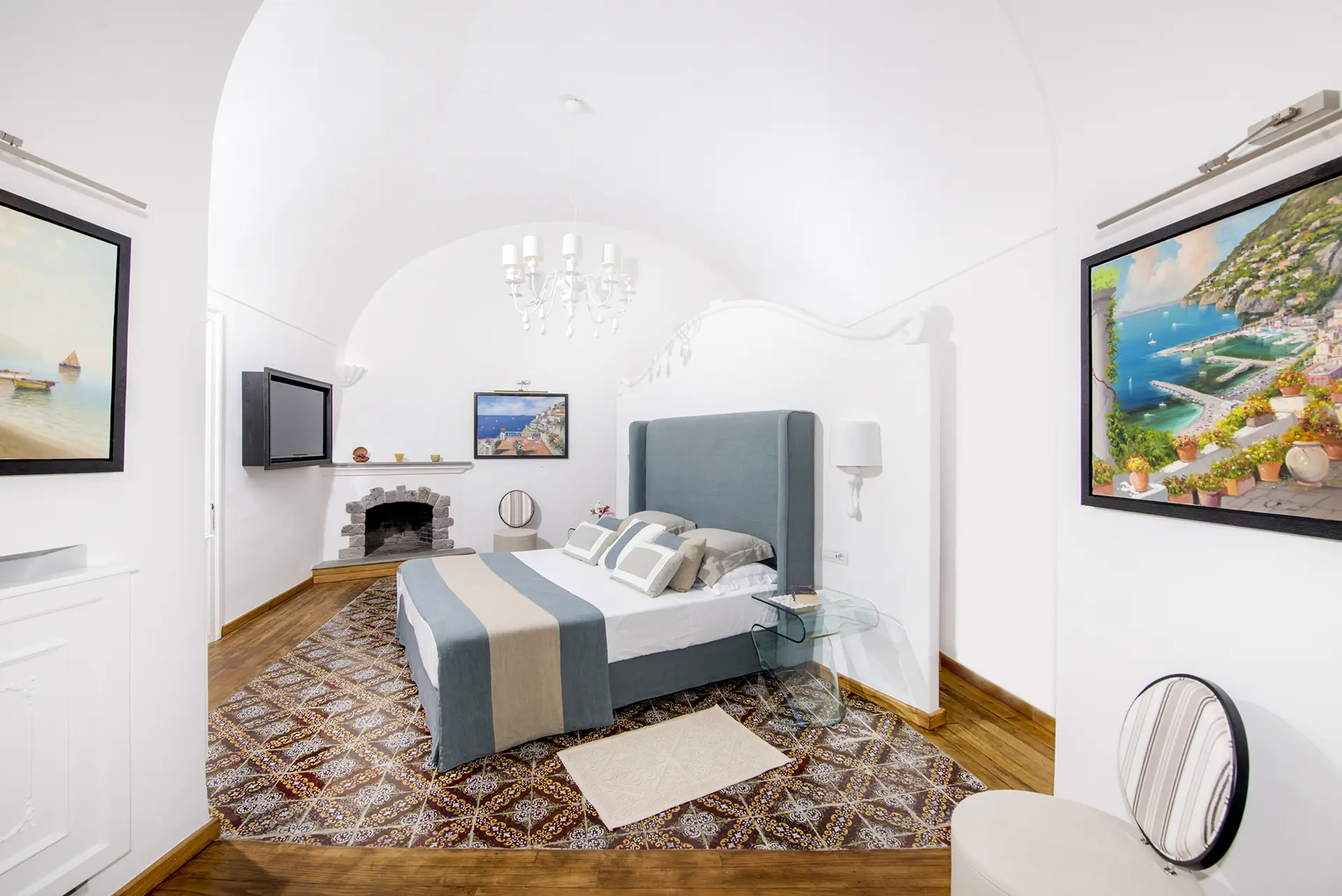 Camera da letto elegante con letto matrimoniale, camino e dipinti sulle pareti.