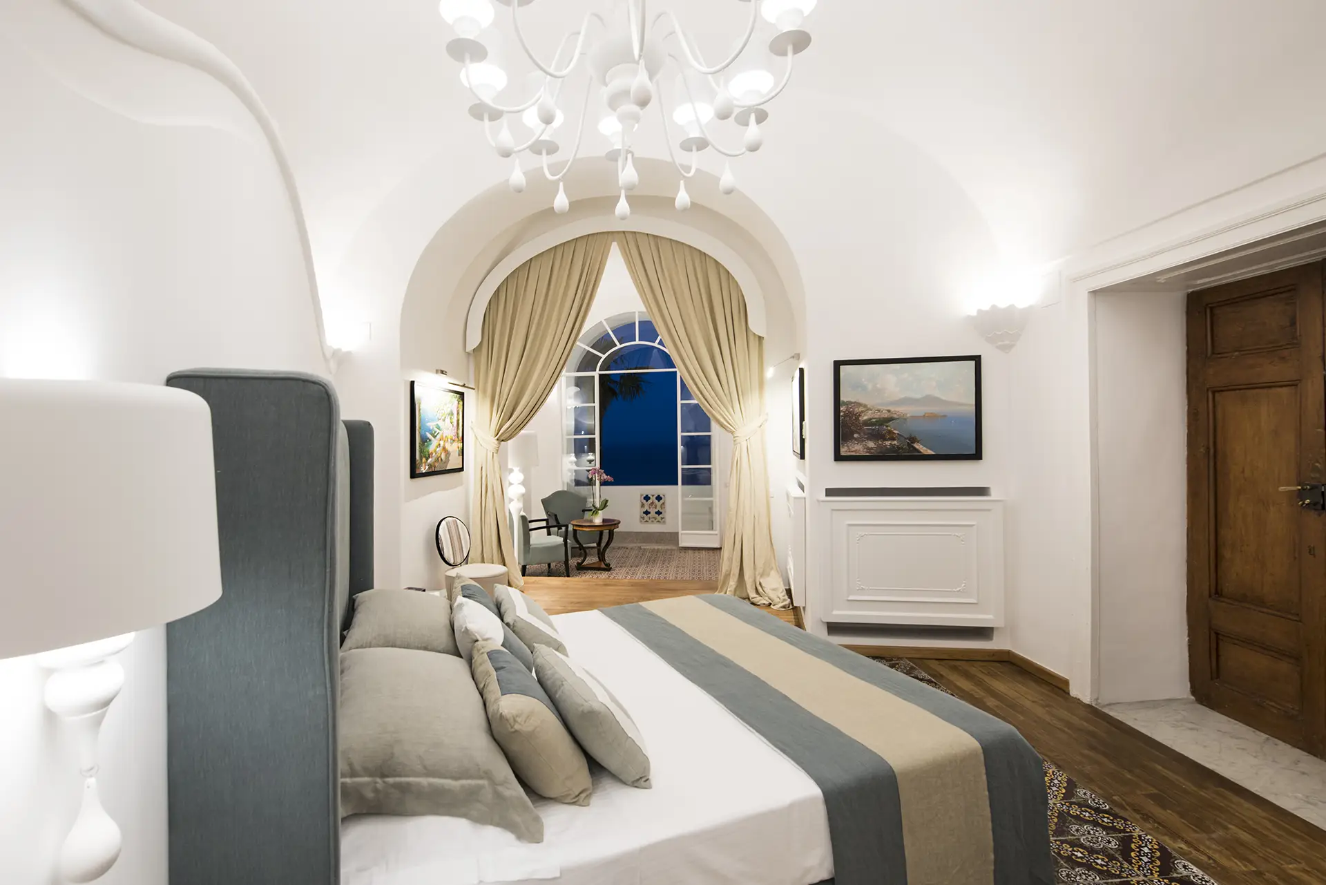 Camera da letto elegante con arredamento raffinato e vista su un balcone.