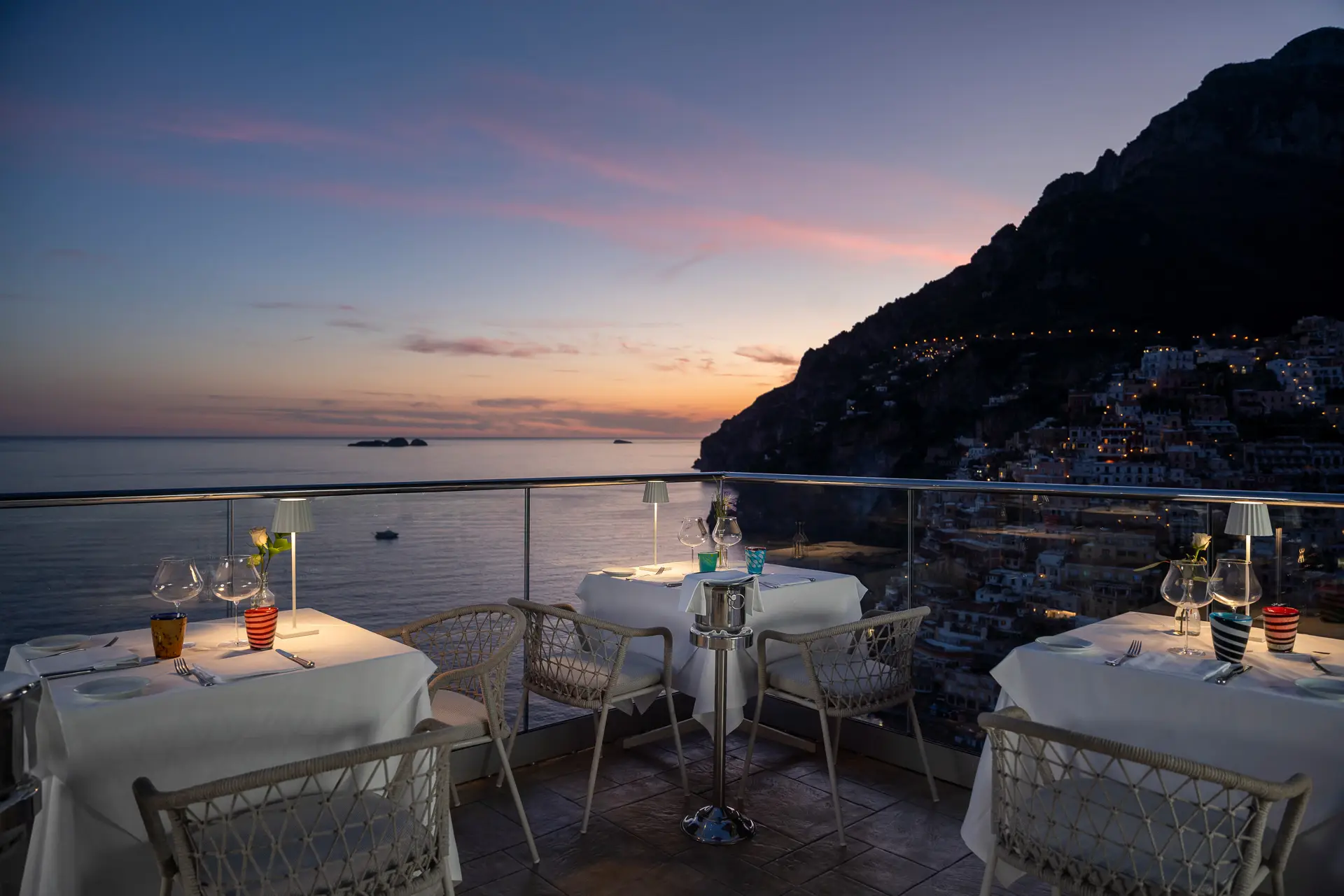 Terrazza di un ristorante con vista sul mare al tramonto.