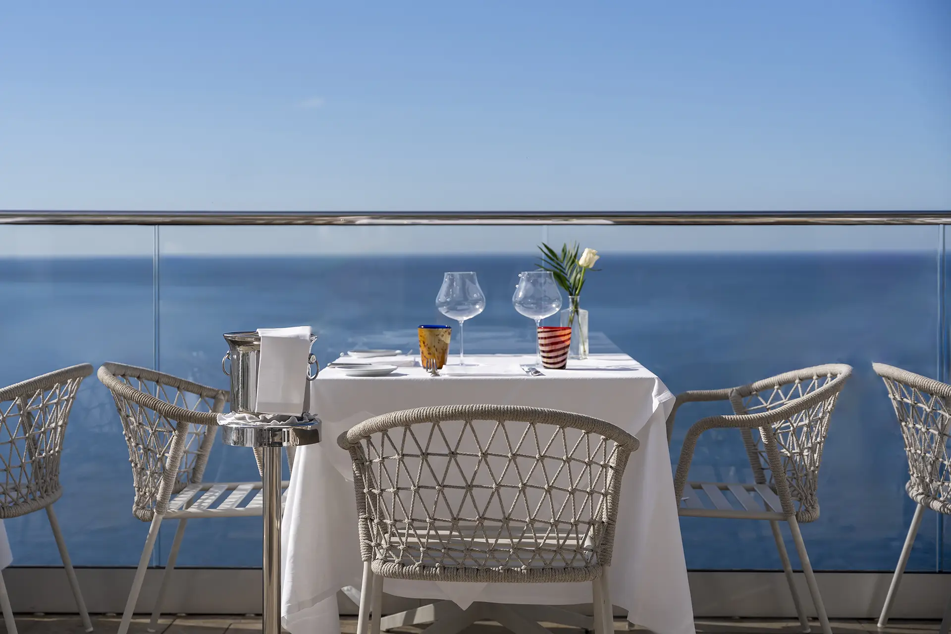 Tavolo da pranzo elegante con vista sul mare azzurro.