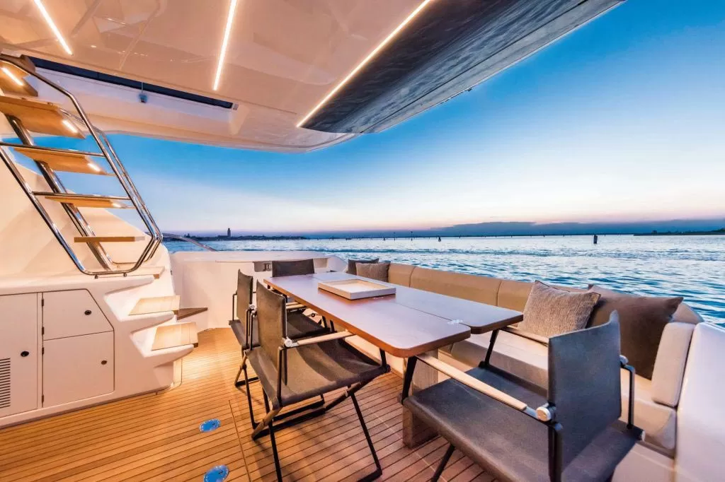 Interno di uno yacht di lusso con vista sul mare al tramonto.