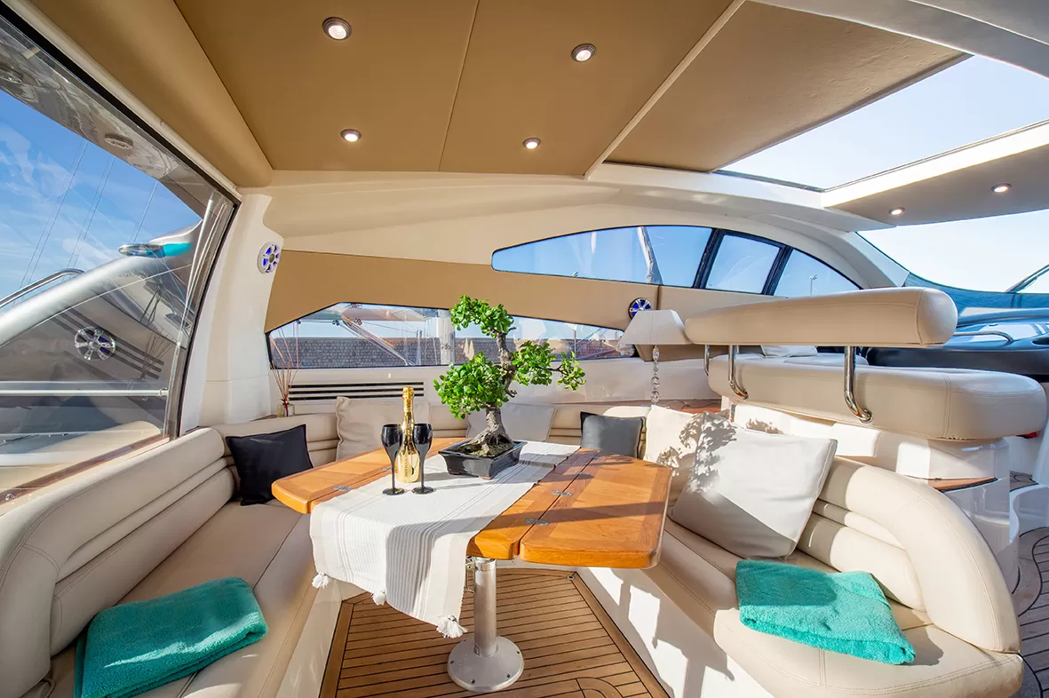 Interno elegante di uno yacht con tavolo, sedili in pelle e vista panoramica.